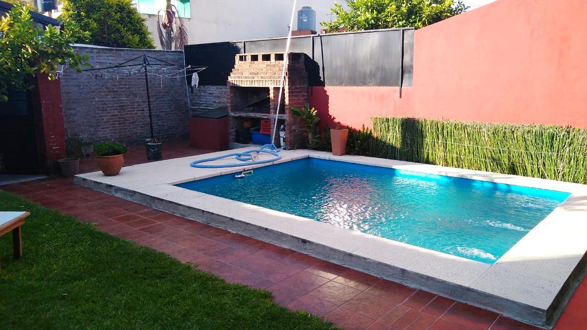 Casa de 2 dormitorios con cochera semicubierta al frente y fondo libre con quincho y piscina.