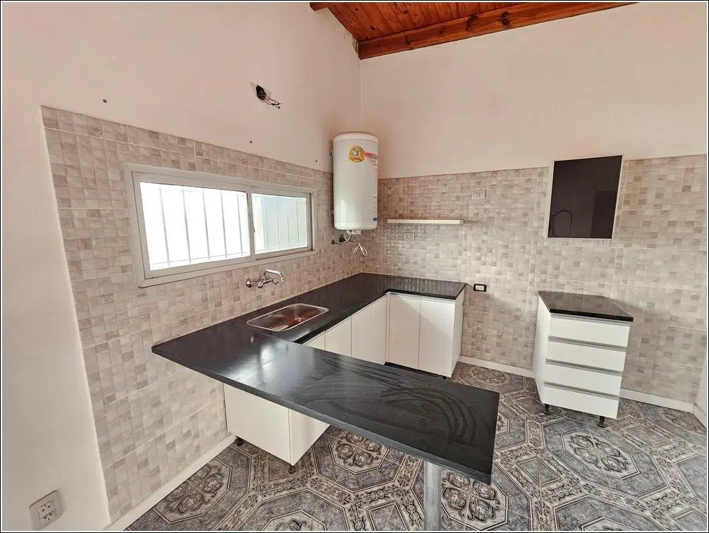 Casa en alquiler de 2 dormitorios con jardín y cochera. Barrio Parque Habitacional Ibarlucea. 1