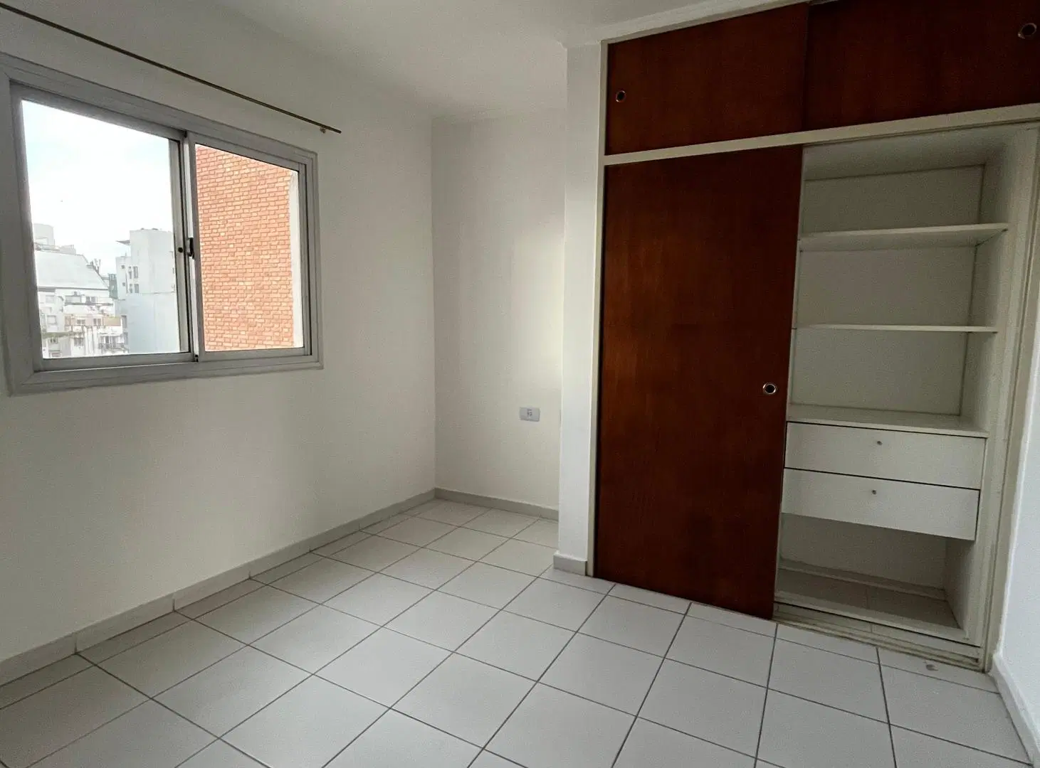 un dormitorio con balcón en Nueva Córdoba 3