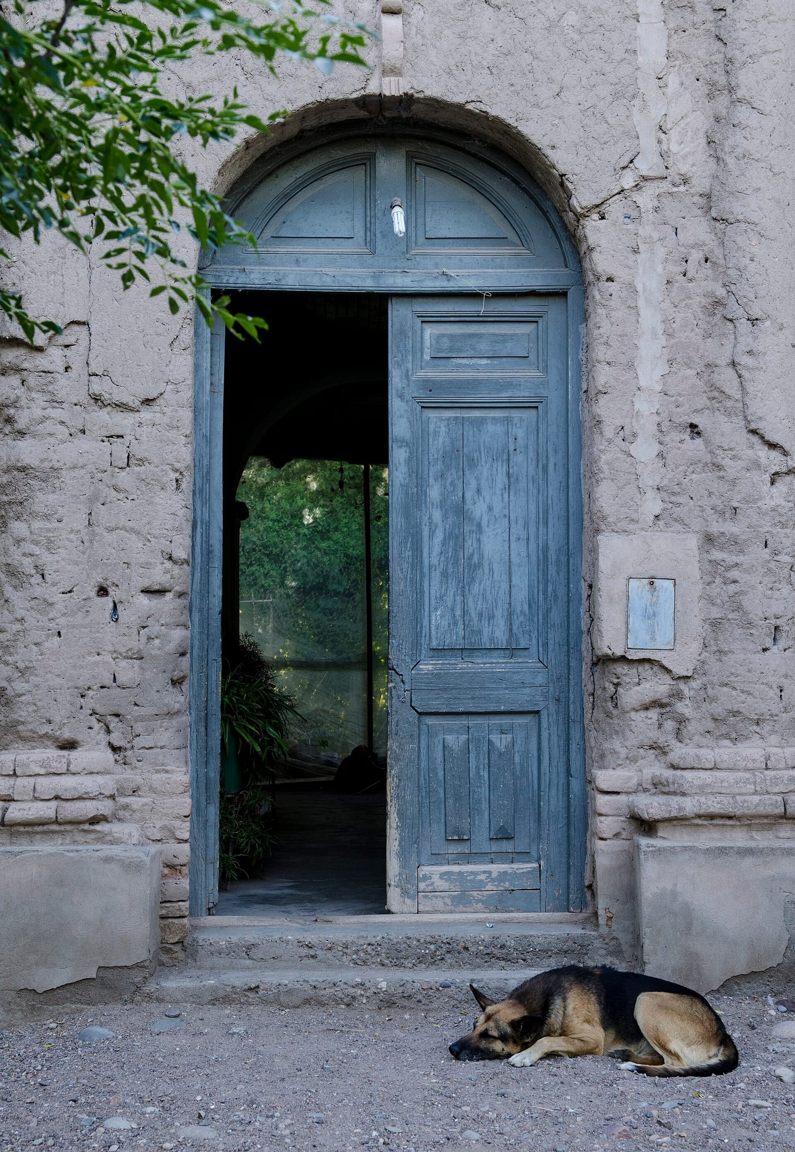 Siesta pueblerina frente a una puerta azul en Chacras de Coria
