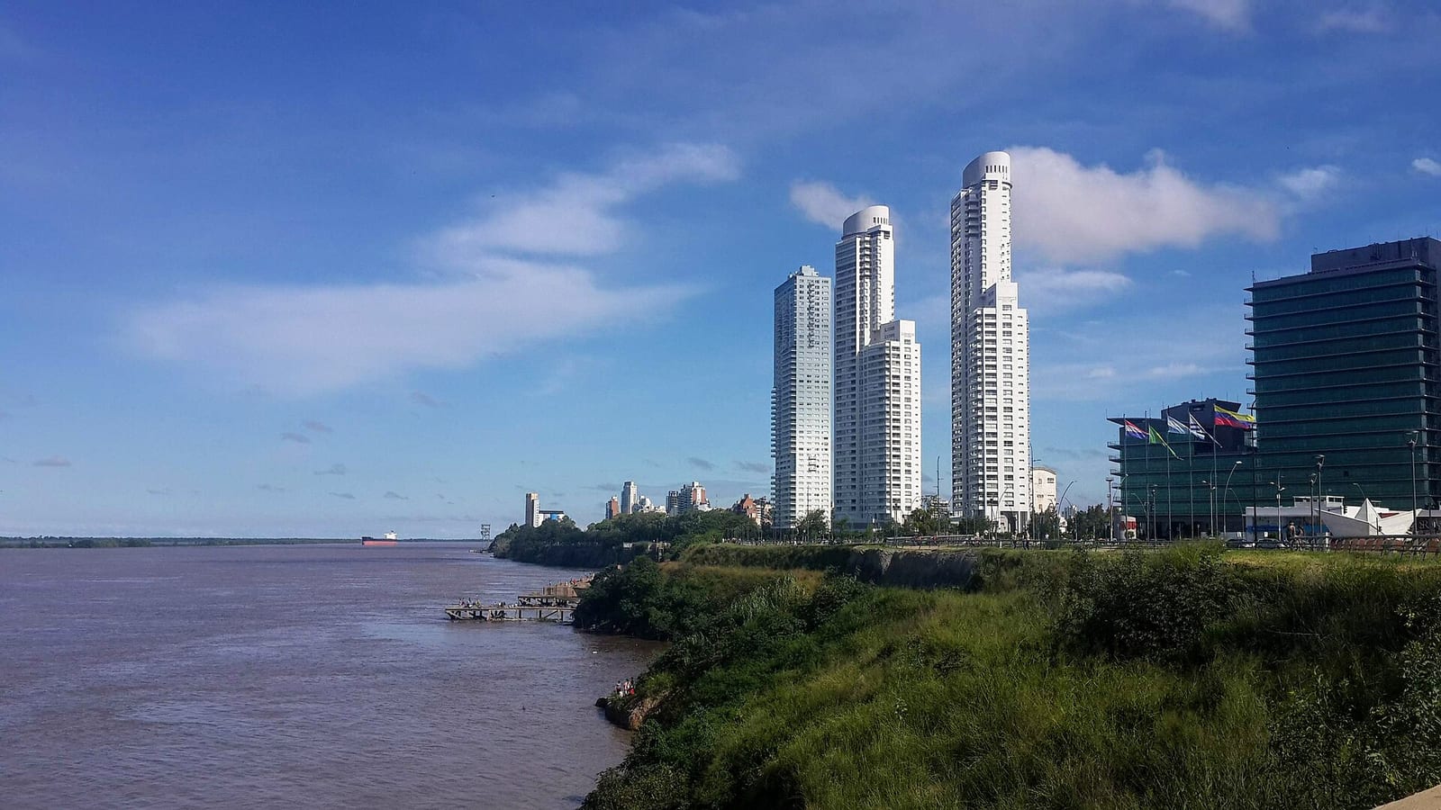 Vista de la costa del Paraná desde Puerto Norte con las torres Dolfines Guaraní y Maui al fondo