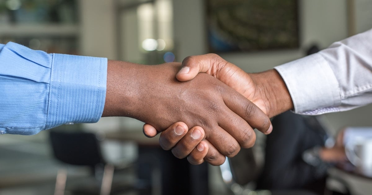 Apretón de manos entre profesionales en reunión de negocios