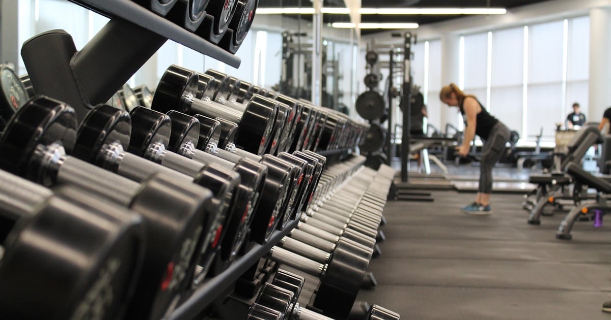 Interior de gimnasio moderno con equipamiento de pesas y cardio