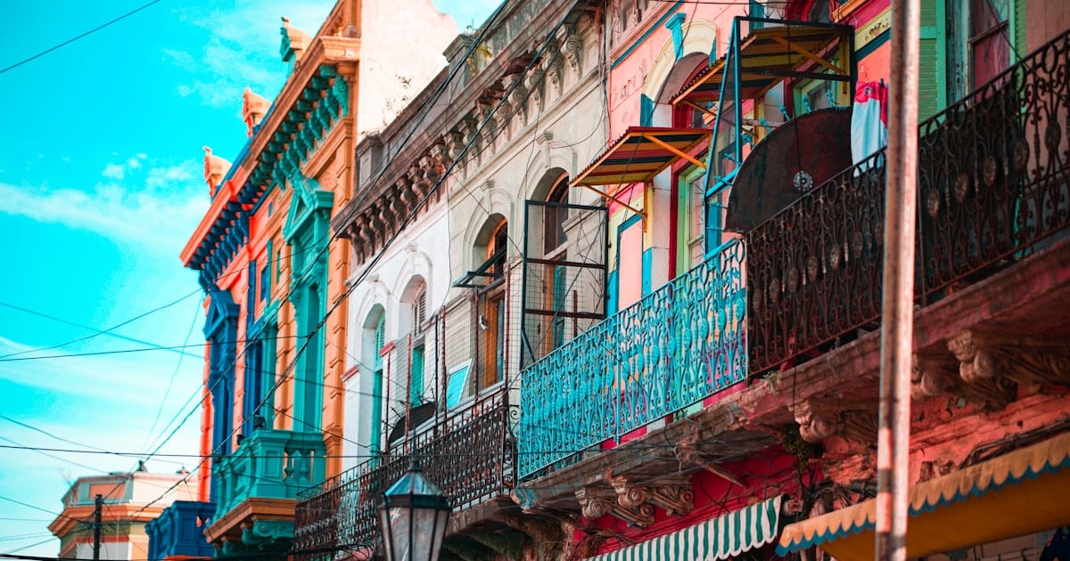 Avenida con cafetería tradicional y edificios de mediana altura en Boedo, Buenos Aires