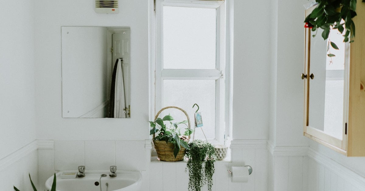 Baño moderno renovado con cerámicos claros y grifería negra